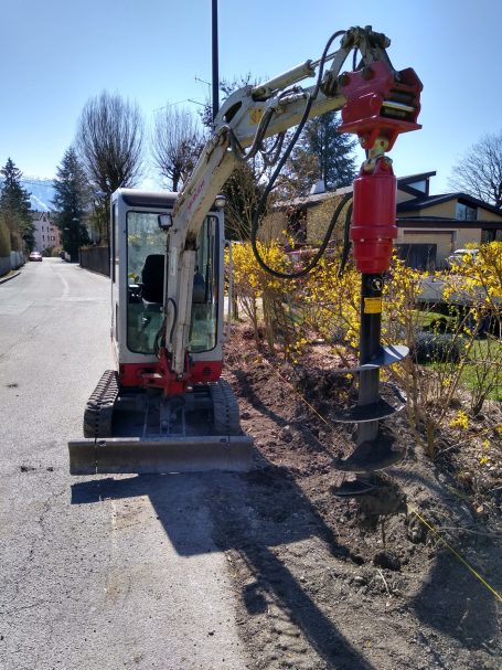 Ottensheim 4100 – Bohrfundamente mit Minibagger Minibagger bohrt Fundamentlöcher in Ottensheim für Zaunpfosten – Bohrfundament im Vorgarten