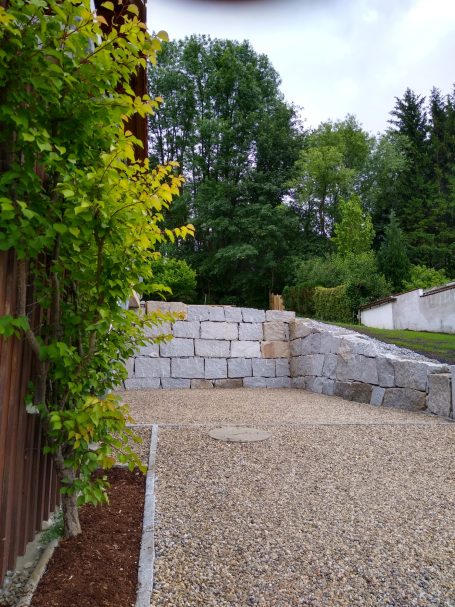 Steinschlichtung Wilhering 4073 – Böschungssicherung Steinschlichtung mit Kettenbagger bei Parkfläche in Wilhering, Naturstein als Böschungssicherung gesetzt.